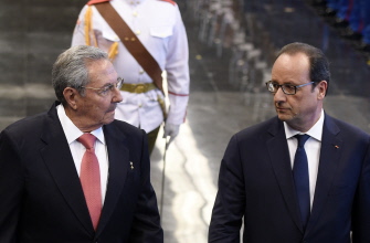 Francois Hollande (d) y el presidente cubano, Raúl Castro, revisan una guardia de honor en el Palacio de la Revolución, en La Habana