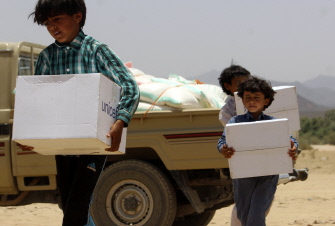 Niños yemeníes que huyeron con sus familias de Sirwah debido a los combates, cargan ayuda humanitaria de UNICEF en su centro de refugiados