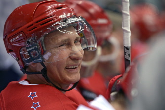 Putin sonríe en la banca durante un partido de hockey sobre hielo en un torneo de liga nocturna en Sochi