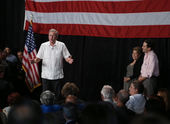 Jeb Bush habla mientras su mujer Columba (2d) y su hijo Jeb Jr. (d), escuchan en un acto para recaudar fondos en Sweetwater, Florida 
