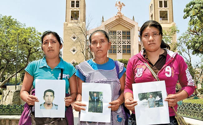 Mujeres muestran fotografías de sus familiares desaparecidos en la semana del 9 al 14 de mayo.
