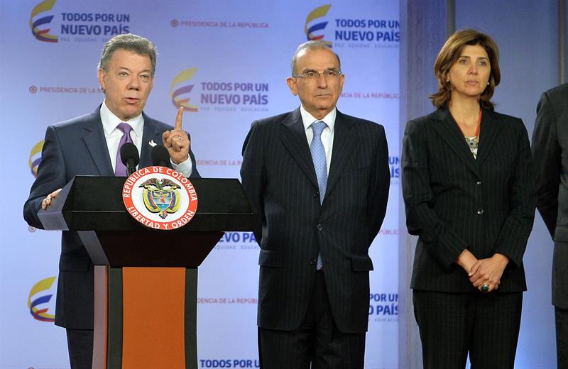 Santos (i), al anunciar en Bogotá que la canciller María Ángela Holguín (d) y el empresario Gonzalo Restrepo se unirán al equipo negociador 