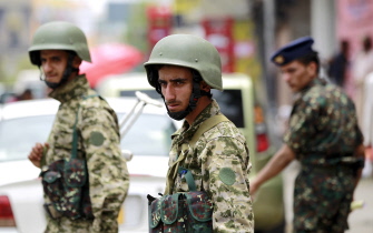 Dos soldados yemeníes controlan los automóviles que circulan en una calle de Saná, la capital del país