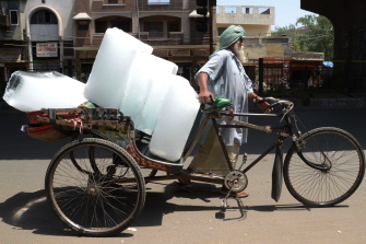 Un trabajador indio utiliza un "rickshaw" (bicicleta de tres ruedas) para transportar hielo desde una fábrica en Amritsar