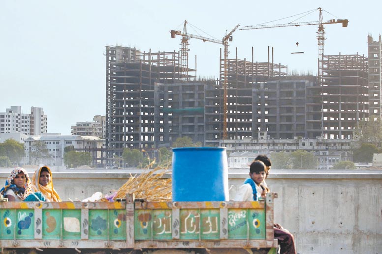 Trabajadores viajan hacia los edificios en obra en Ahmedabad.