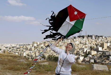 Una mujer se prepara para volar una cometa durante un evento para celebrar el Día de la Independencia de Jordania.
