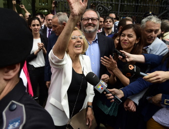 Manuela Carmena, la nueva alcaldesa de Madrid, saluda al dejar el Palacio de Cibeles, sede del ayuntamiento, después de jurar su cargo