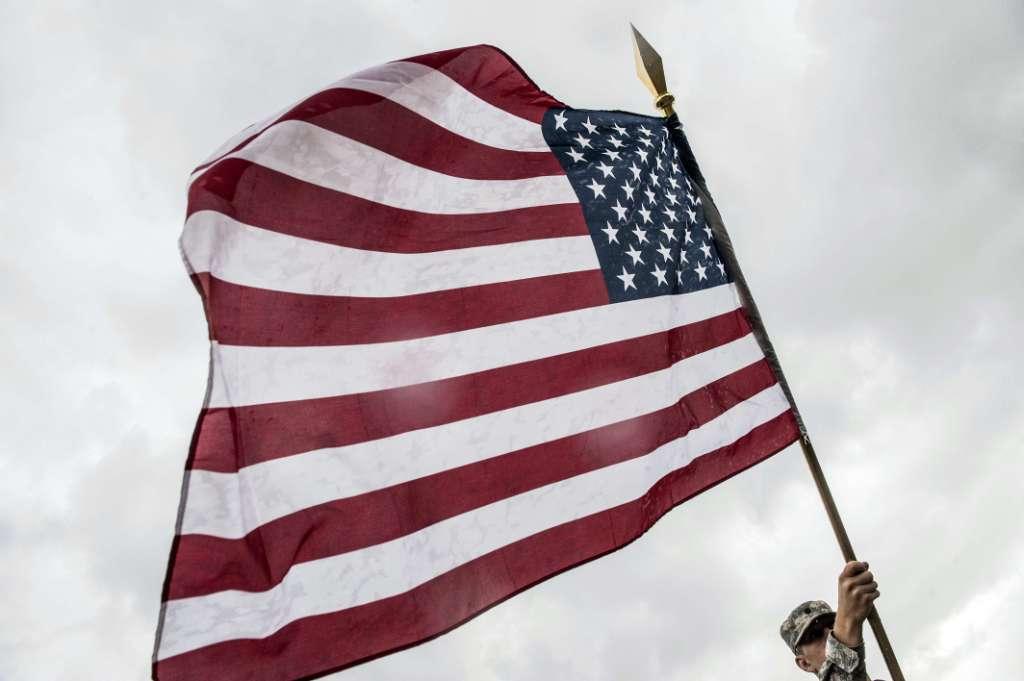 Un militar sostiene la bandera de Estados Unidos durante su visita en la ciudad de Ferizaj, como parte de su misión de paz en la OTAN en Kosovo.