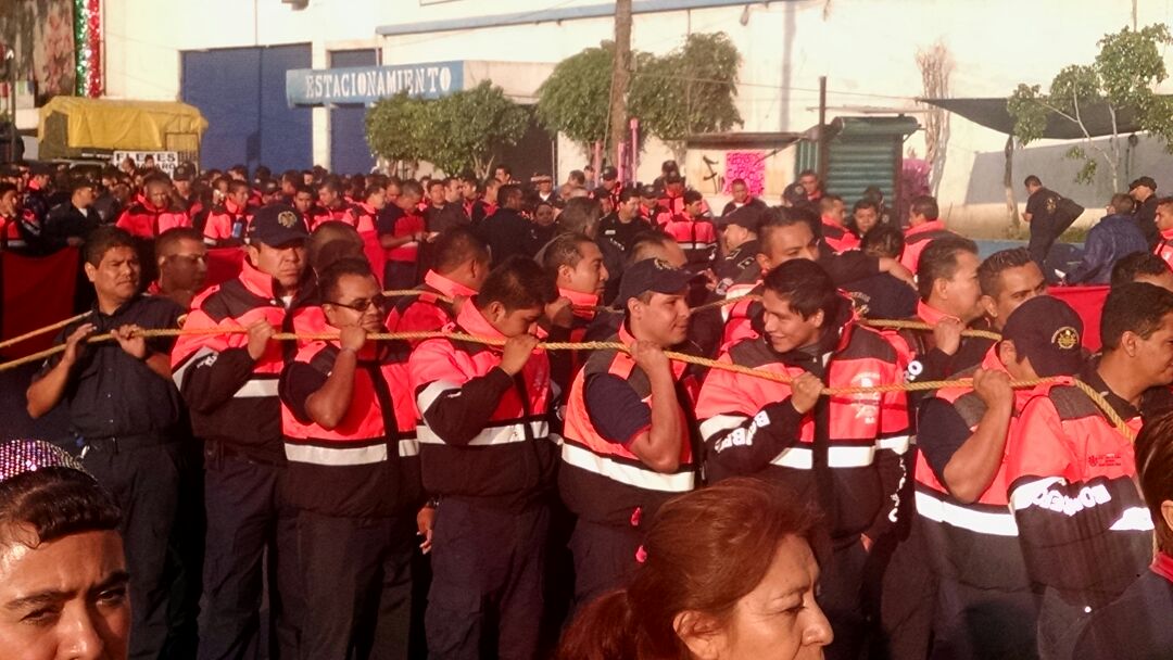 Los manifestantes jalan con cuerdas un camión de bomberos descompuesto.