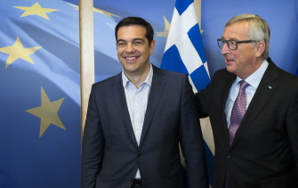 El primer ministro griego, Alexis Tsipras (i), es recibido por el presidente de la CE, Jean-Claude Juncker (d), antes de la reunión de esta noche