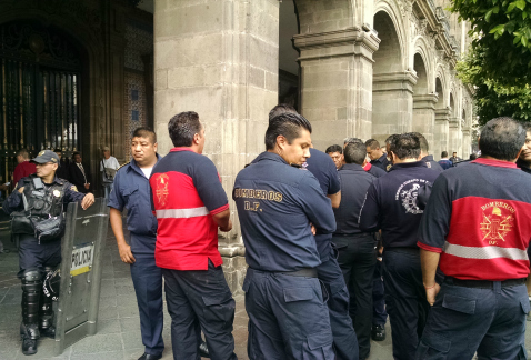 Representantes de estaciones de bomberos esperan la salida de una comisión reunida con el jefe de Gobierno capitalino, Miguel Ángel Mancera, al que pi