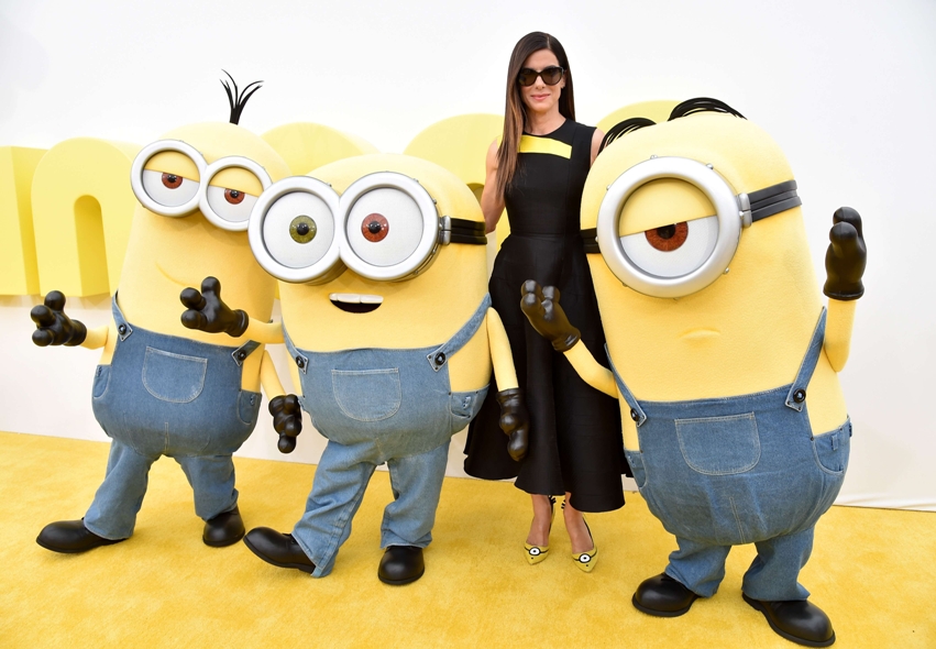 Los Minions abrazaron a Sandra Bullock en su paso por la alfombra amarilla de la premier de la película. 
