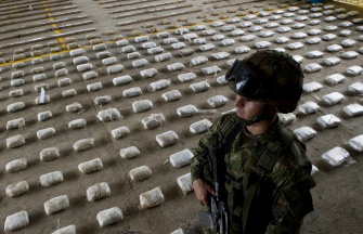 Un soldado colombiano hace guardia junto a paquetes de cocaína confiscados, en Bahía Solano, en el departamento del Chocó