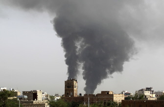 Dos columnas de humo se alzan tras un bombardeo de la coalición árabe a un depósito de armas en un aeropuerto militar rebelde en Saná