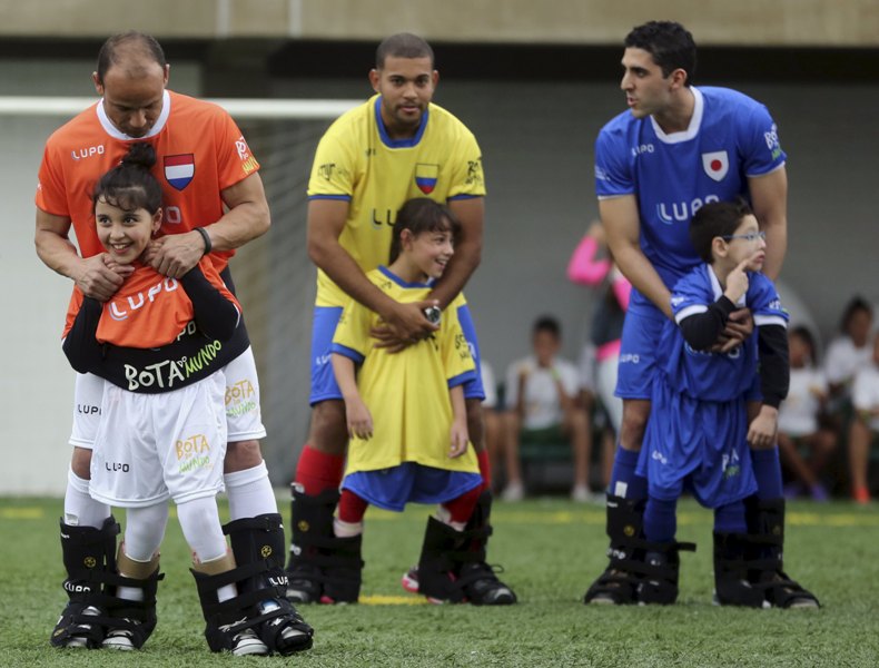 Niños discapacitados juegan futbol con los jugadores del futbol brasileño Leo, Eder y Guilherme 