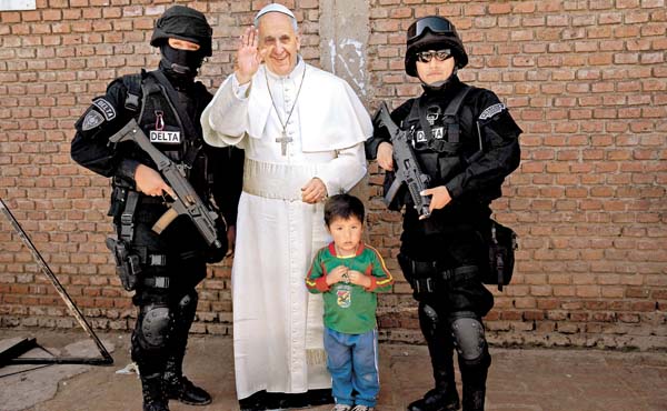 Un niño y dos oficiales de la cárcel posan junto con un cartelón del Papa.
