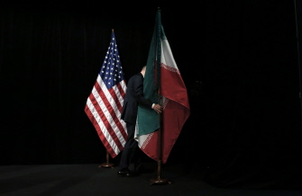 Un trabajador retira la bandera de Irán después de que los cancilleres se hicieran la foto de grupo en el Centro Internacional de Austria, en Viena