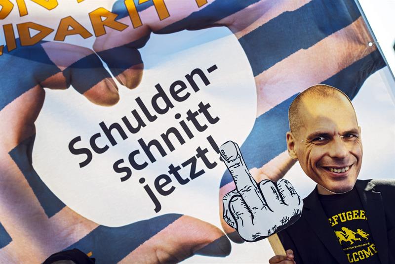 Un globalifóbico del movimiento Attac, con una careta del ex ministro griego Varufakis y el lema "¡Corte de pelo ya!", ante el BCE en Fráncfort 