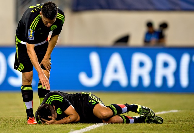 Oribe Peralta trata de levantar a Yasser Corona en el duelo de cuartos de final de la Copa Oro 2015