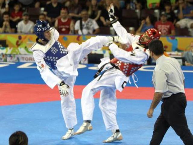 Saúl Gutiérrez (de azul) conecta una patada en la cabeza de su contrincante para ganar la medalla de oro