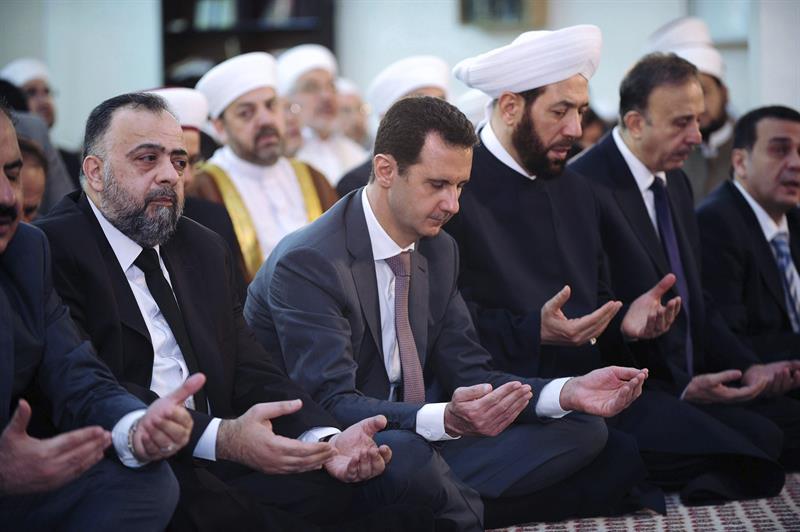 El presidente sirio, Bashar al Asad (c), durante un rezo con motivo del inicio del festival islámico Eid-ul-Fitr en Damasco