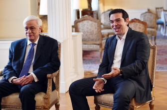 El primer ministro, Alexis Tsipras (d), habla con el presidente, Prokopis Pavlopoulos, antes de una comida por los 41 años del régimen democrático