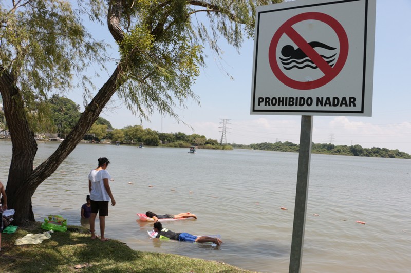 Turistas nadan en la laguna del Chairel, pese a letreros de advertencia. 
