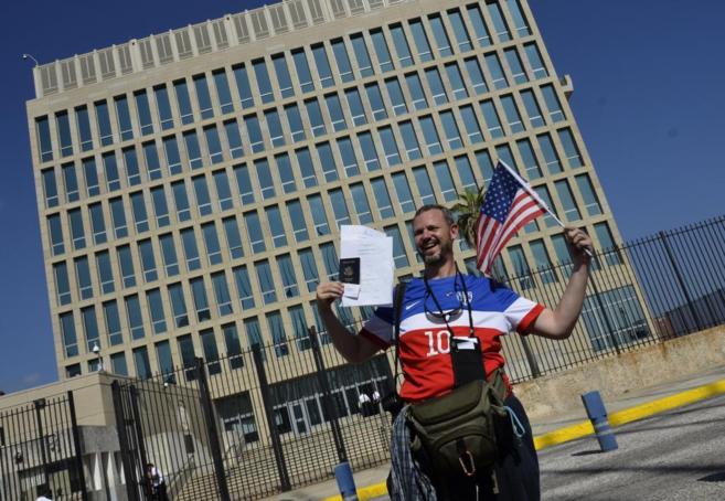 Un hombre enseña sus documentos migratorios tras una gestión realizada, ante la embajada de Estados Unidos en La Habana