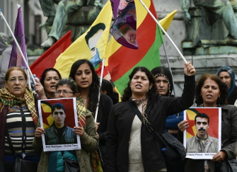 Manifestantes kurdos gritan consignas mientras muestran fotografías de las víctimas del ataque suicida en Suruc, hoy en una protesta en Bruselas
