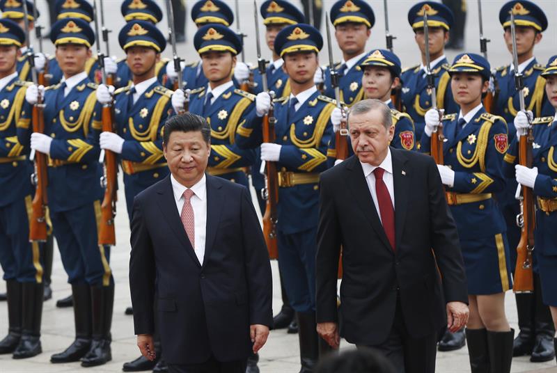 El presidente turco, Recep Tayyip Erdogan (d), pasa revista a la guardia de honor con Xi Jinping (i), en el Gran Palacio del Pueblo de Pekín