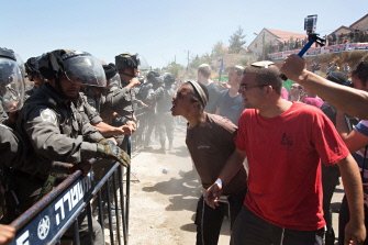 Colonos israelíes discuten con soldados durante la demolición de los edificios Dreinoff, por orden judicial, en Beit El, al norte de Ramala