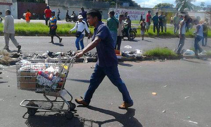 Un saqueador del supermercado, con un carrito lleno de productos robados en el establecimiento