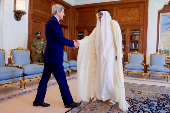 El emir de Catar, jeque Tamim bin Hamad al-Thani (d) saluda a John Kerry antes de su entrevista en el palacio Diwan de Doha