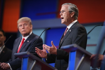 Jeb Bush (d) contesta una pregunta durante el debate en el Quicken Loans Arena de Cleveland, mientras Donald Trump (i) a su lado escucha 