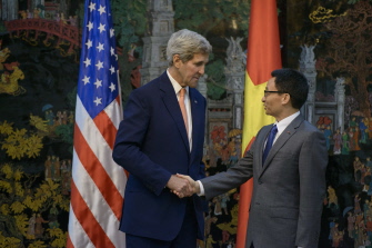 John Kerry (i) saluda al primer ministro de Vietnam, Vu Duc Dam, antes de su encuentro hoy en Hanoi 