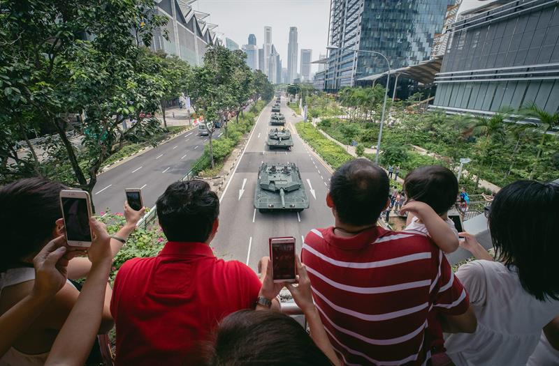 Una multitud contempla el paso de los tanques en el desfile militar en el Día Nacional en Singapur