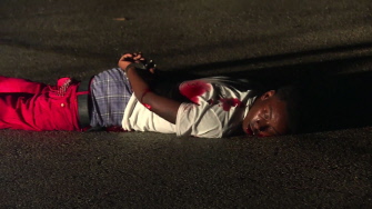 En esta imagen de video aparece un sospechoso en el piso, esposado, tras ser herido por la policía de Ferguson tras disparar contra los agentes