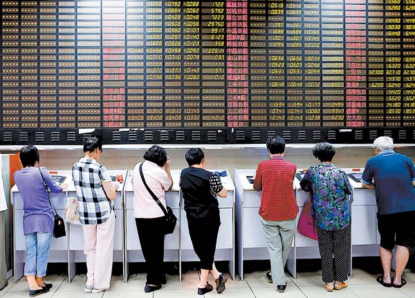 Inversores revisan los movimientos de los títulos en Shanghái. 