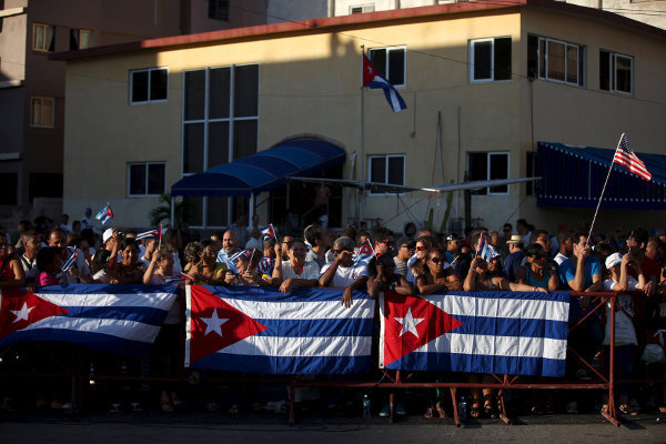 En las inmediaciones de la embajada de EU en La Habana, empiezan a congregarse cubanos que, portando banderas de Cuba y de Estados Unidos, acuden para
