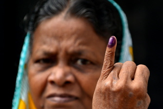 Una mujer ceilandesa muestra un dedo manchado de tinta como prueba de haber votado en un centro electoral de Colombo, este lunes