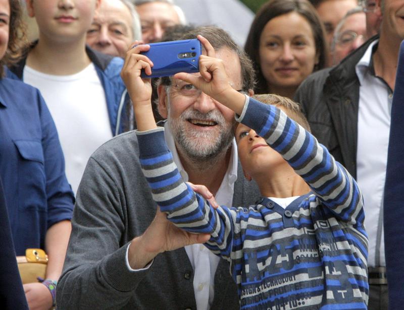 Mariano Rajoy posa para hacerse un "selfie" con un niño, durante la visita que realizó recientemente a la zona ganadera de Ódenes, en Galicia