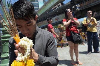 Varias personas rezan y sostienen barras de incienso en el templo de Erawan, donde tuvo lugar el atentado el lunes en Bangkok