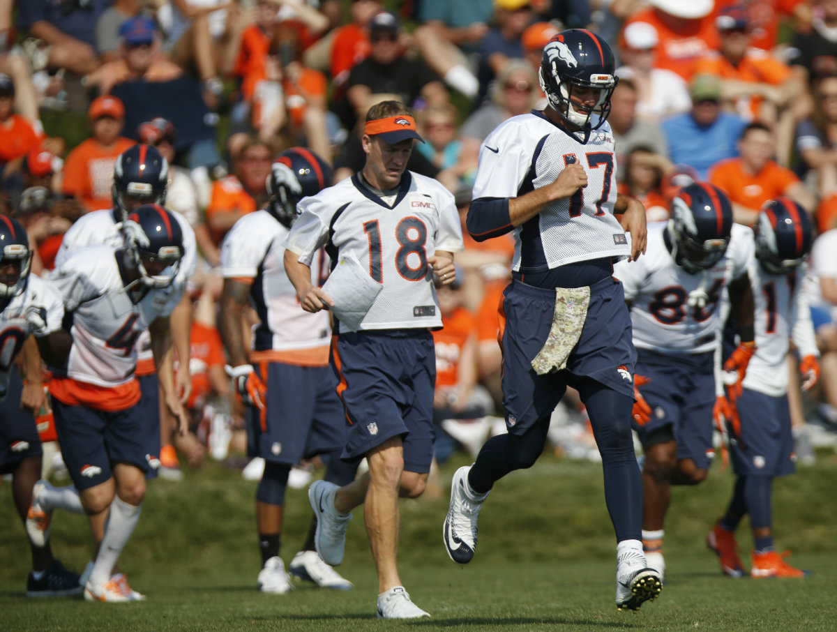 El quarterback Brock Osweiler (17), suplente de Peyton Manning (18)