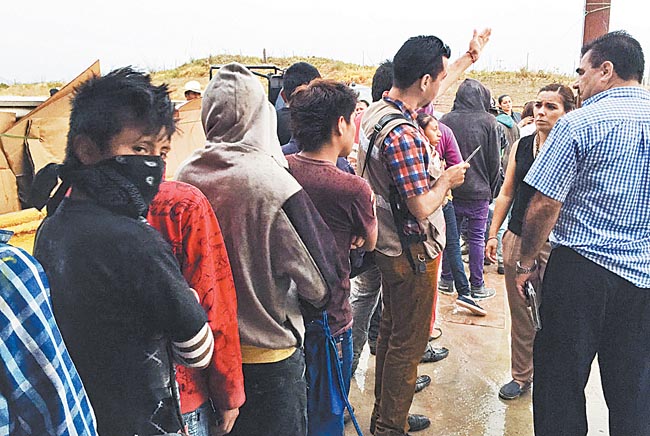 Jornaleros hacen fila en espera de recibir la ayuda de las autoridades. 