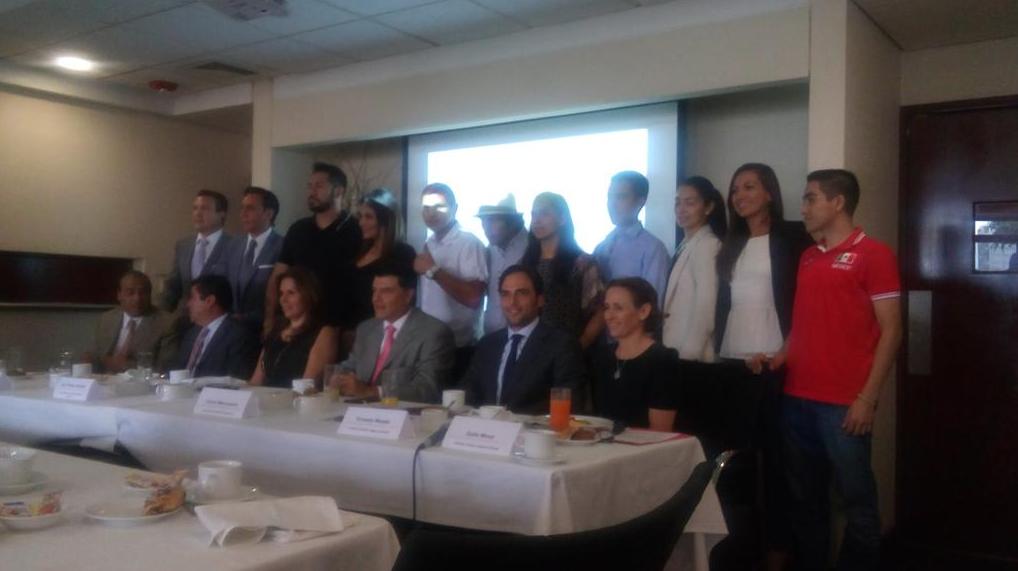 Carlos Mercenario (corbata rosa) en la conferencia; detrás, Mariana Juárez entre otros deportistas