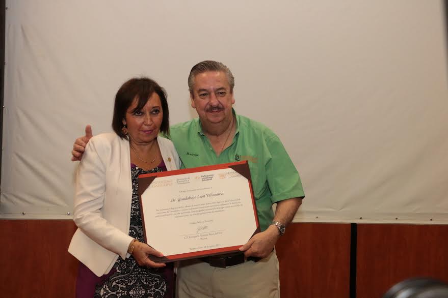 El rector de la UAT entrega reconocimiento a Guadalupe León Villanueva, secretaria de Finanzas de la UNAM.