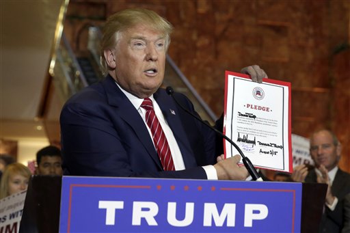 Donald Trump muestra un documento firmado por el que se compromete a mantener fidelidad al partido republicano, hoy en Nueva York