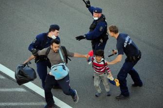 Una familia de emigrantes es empujada fuera de la carretera por la policía húngara en la autopista M5, en Röszke, cerca de la frontera con Serbia