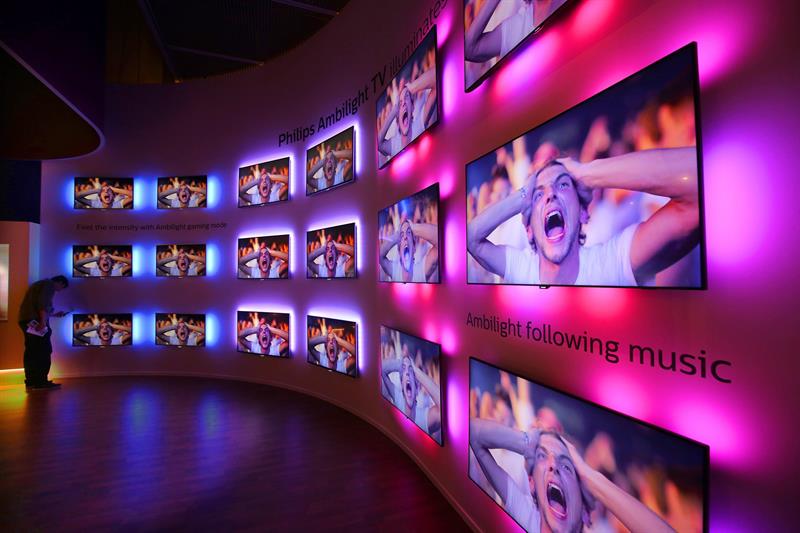 Un visitante revisa las televisiones con Ambilight ,un sistema de retroiluminación, de Philips.