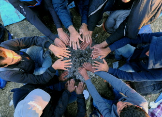 Refugiados calientan sus manos sobre las cenizas de una hoguera en un centro de control cerca de la villa húngara de Röszke